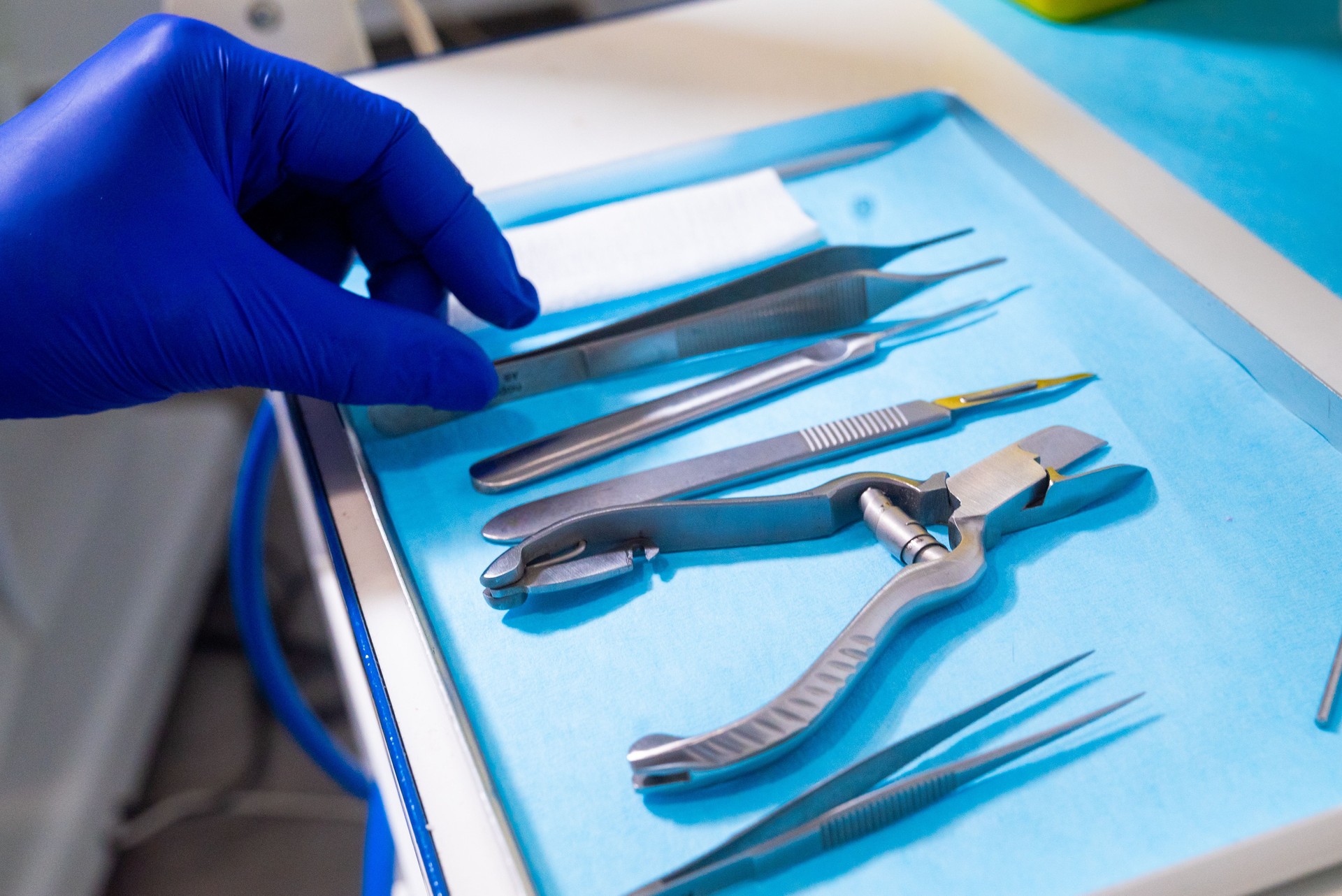 Medical tools on a tray with a gloved hand