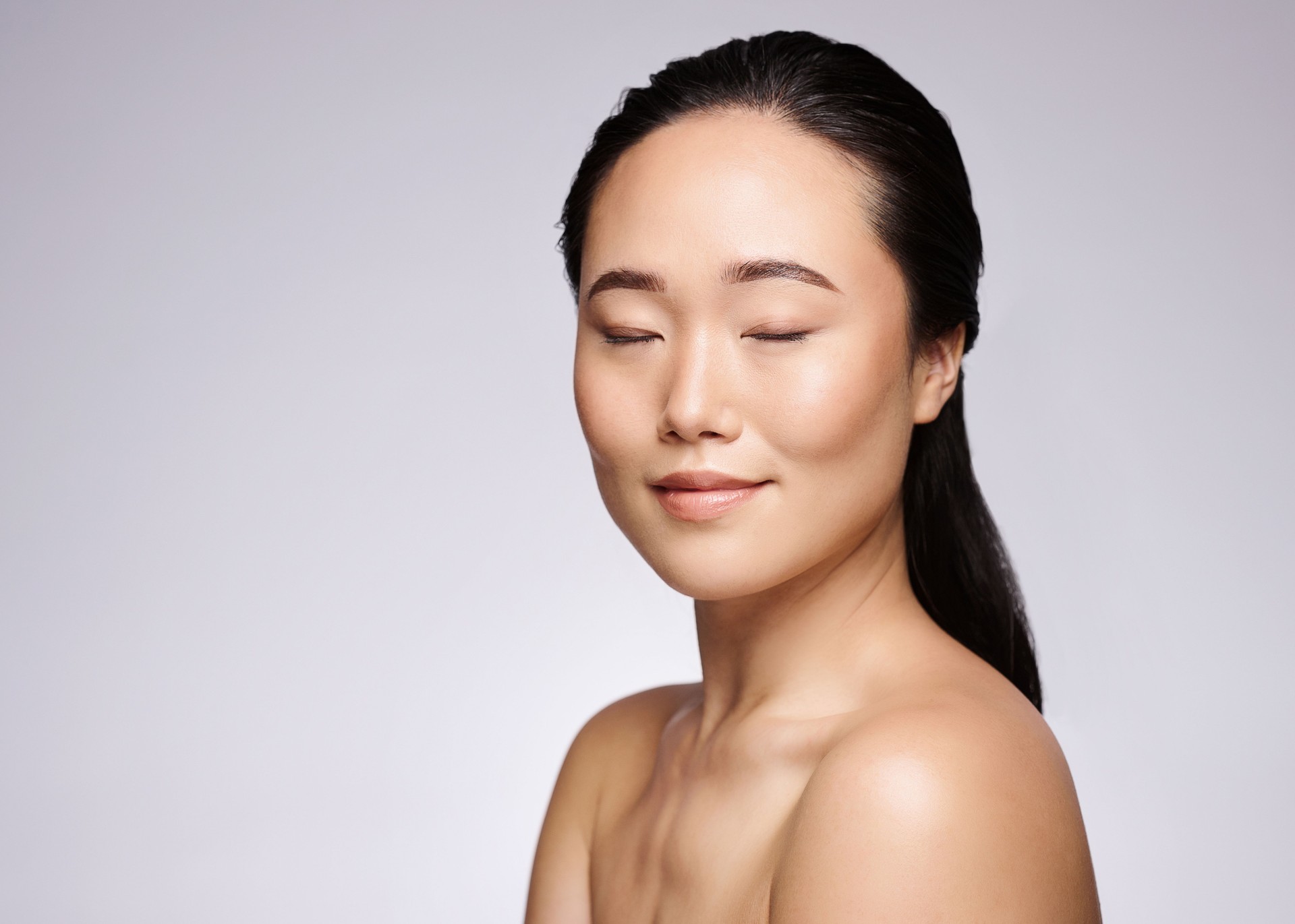 Asian woman, eyes closed and beauty on studio background for natural skincare, makeup or cosmetics. Korean model, face headshot and wellness, glow or luxury salon facial, aesthetic health and mockup